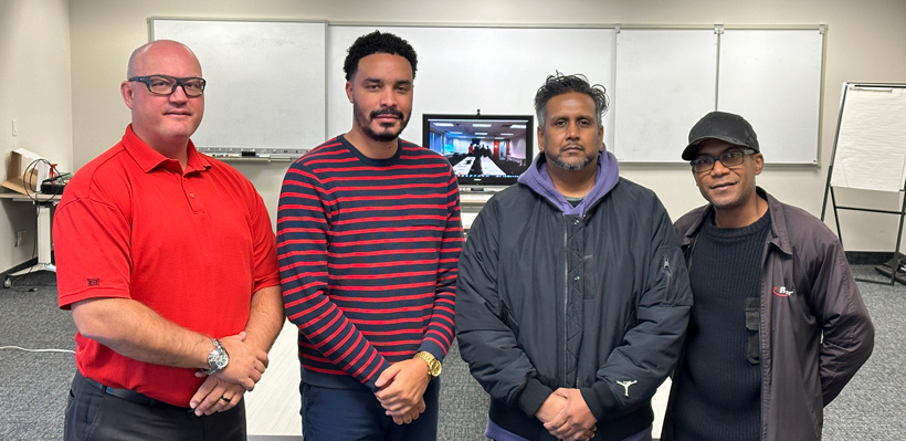 Four members of the Ryder negotiations committee pose for a photo during a bargaining session. 