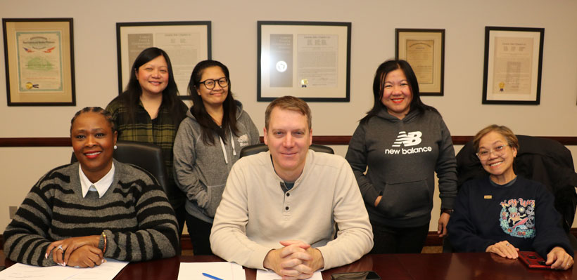 Members of the Plaza Premium Lounge Negotiations Committee pose for a photo during a negotiations session at the union office. 